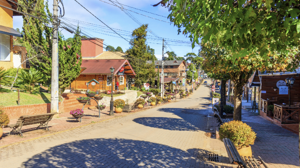 Rua arborizada e clima de montanha em Camanducaia, no Sul de Minas
