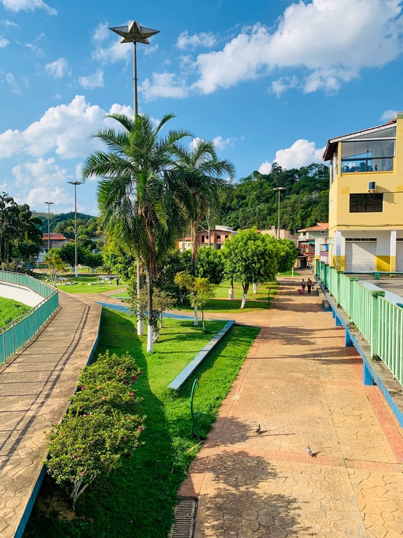 Área pública e paisagem urbana de cidade do interior paulista, com calçadas, árvores e céu parcialmente nublado