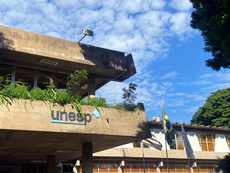Prédio da Unesp em Presidente Prudente, com fachada de concreto e bandeiras ao fundo