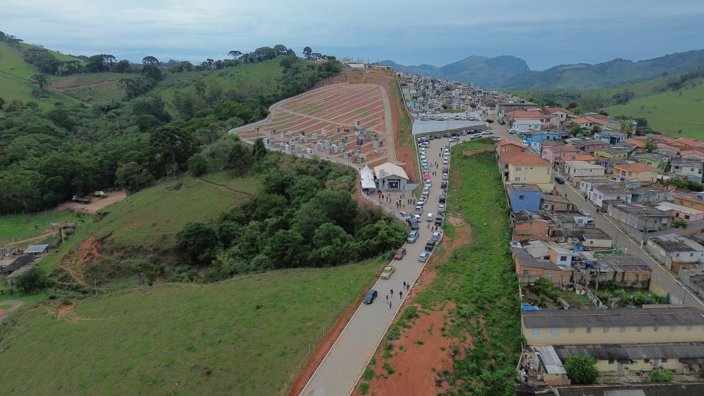 Vista panorâmica de Maria da Fé ao entardecer, com áreas urbanas e montanhas ao fundo