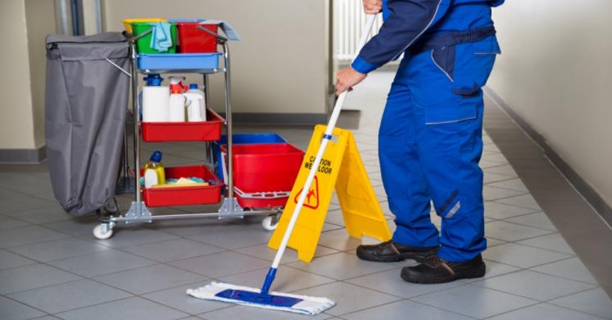 Profissional de limpeza atuando em corredor escolar