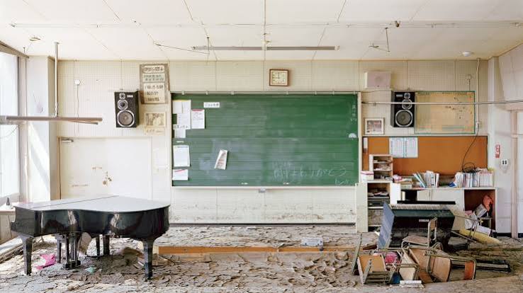 Sala de aula vazia de escola municipal brasileira, com carteiras e quadro, luz natural