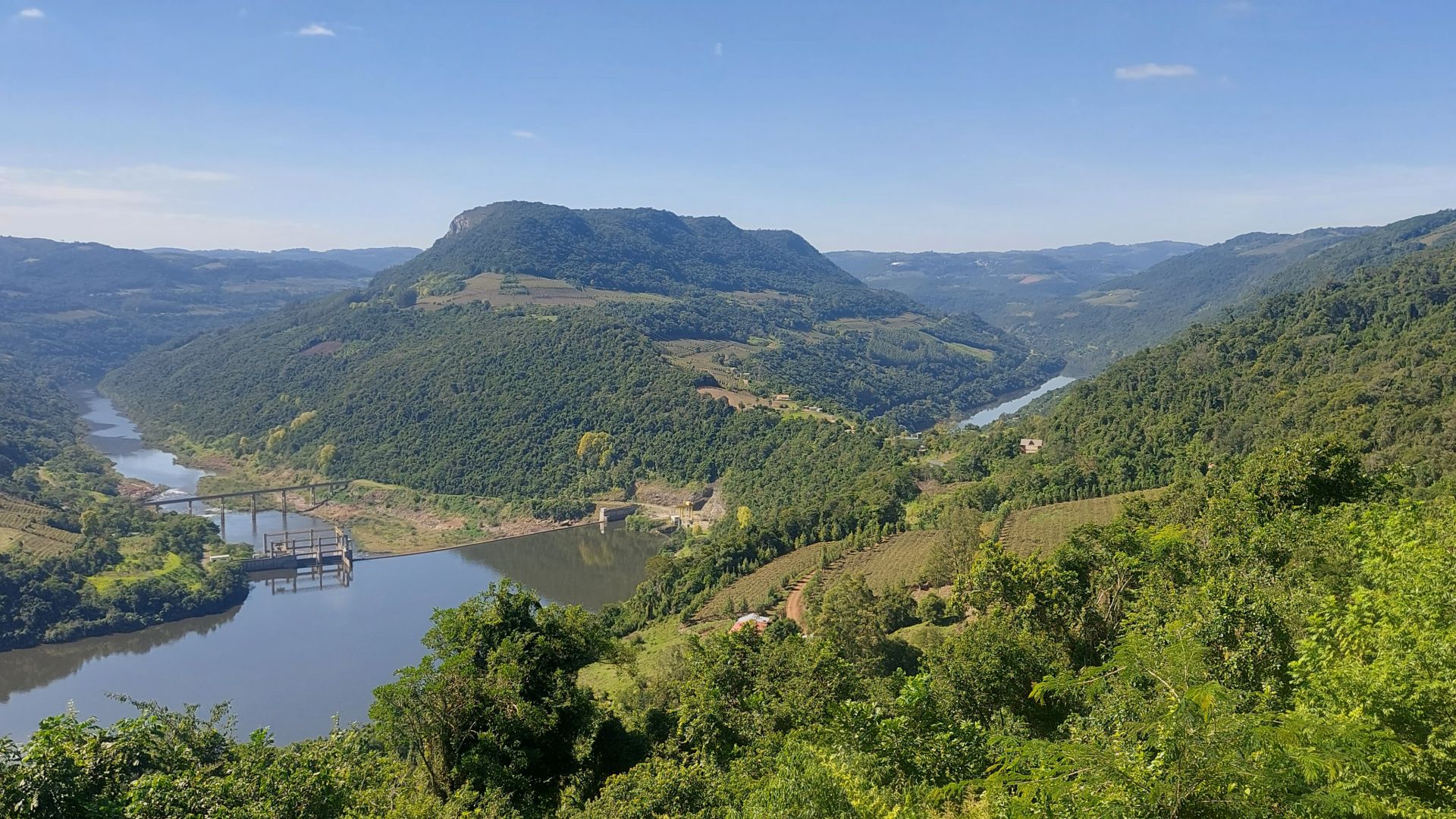 Paisagem da Serra Gaúcha com morros verdes e pequena cidade ao fundo