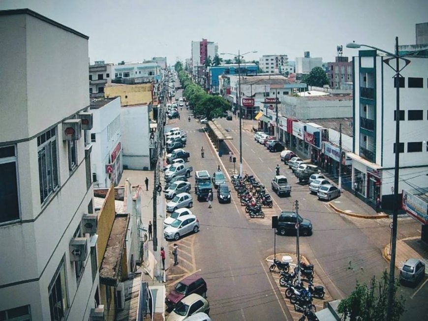 Vista urbana de Cacoal, com avenida arborizada e comércio em destaque