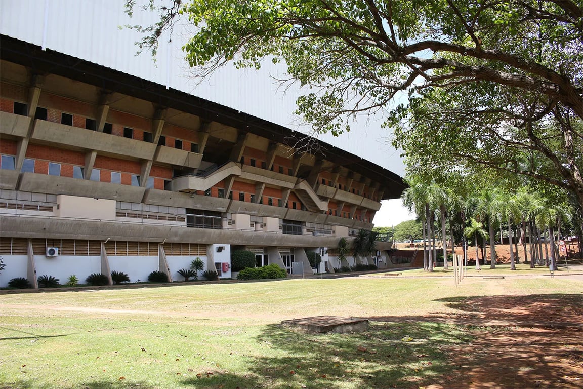 Entrada de campus universitário no Brasil, com árvores e circulação de pessoas