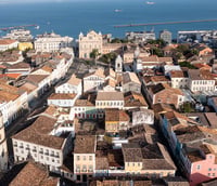 Vista aérea de Salvador BA ao entardecer, com o mar e prédios no horizonte