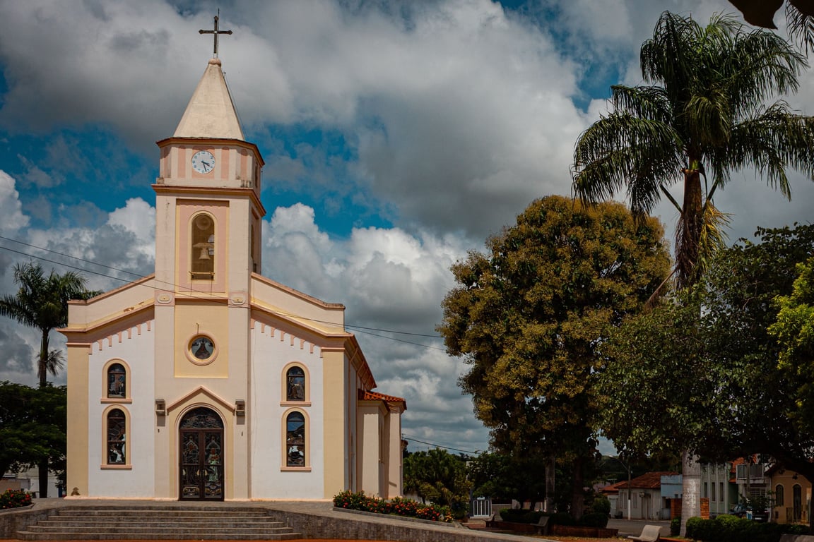 Praça central em cidade do interior de MS, com igreja e área arborizada