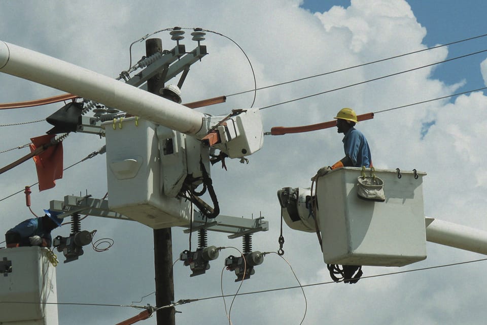 Trabalhadores executando manutenção elétrica com EPI