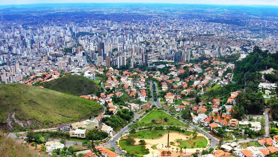 Panorâmica de Belo Horizonte com áreas verdes e prédios, em dia claro