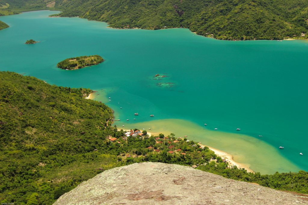 Foto panorâmica do Rio São Francisco em Minas Gerais ao entardecer, com tons dourados e barcos ancorados.