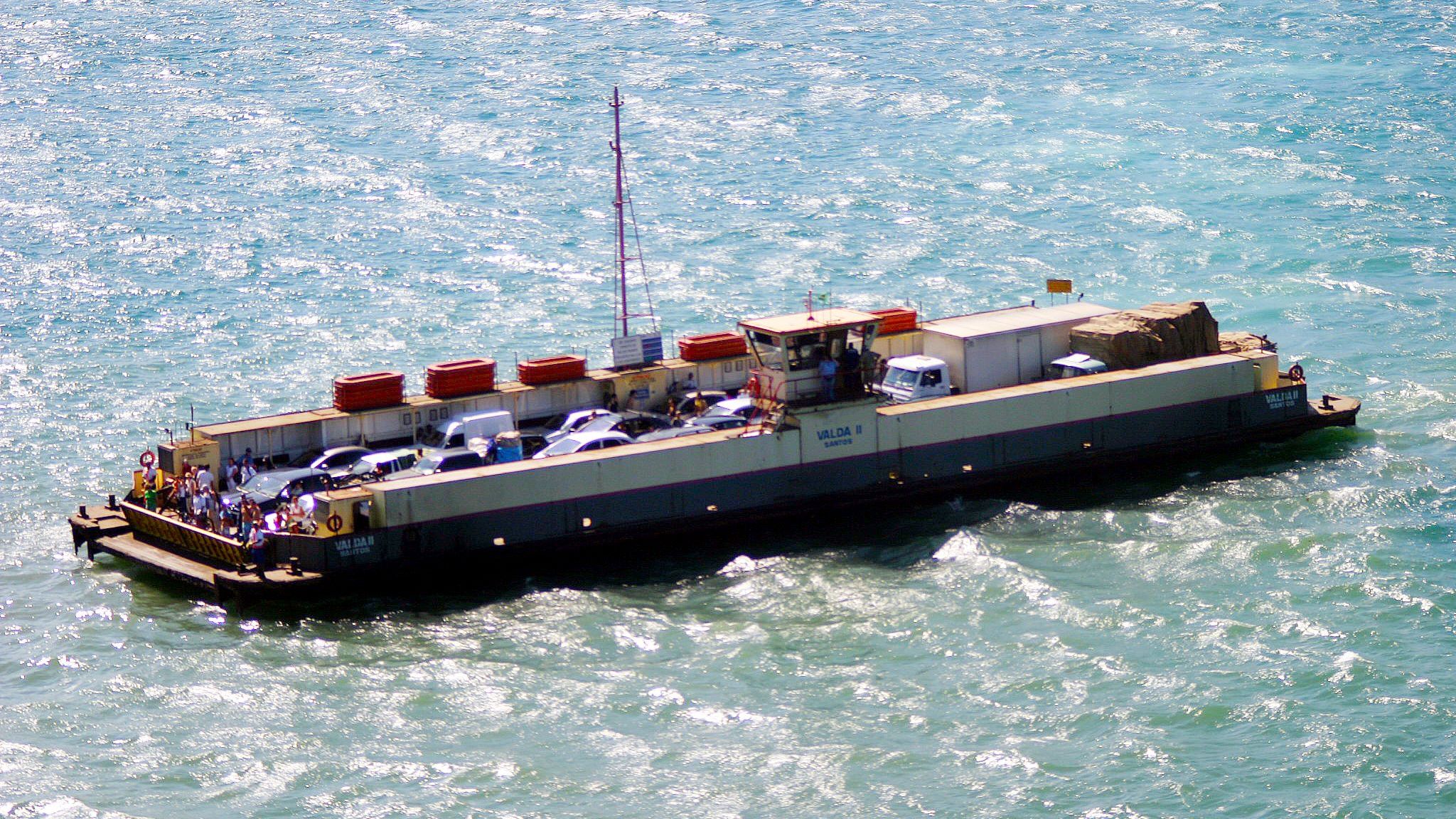 Balsa com carros na travessia São Sebastião–Ilhabela, com serra ao fundo