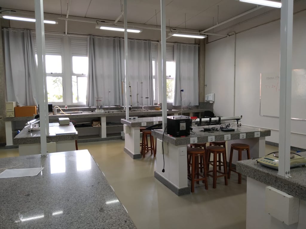 Laboratório de Química educacional, com bancadas, vidrarias e capela, em ambiente acadêmico