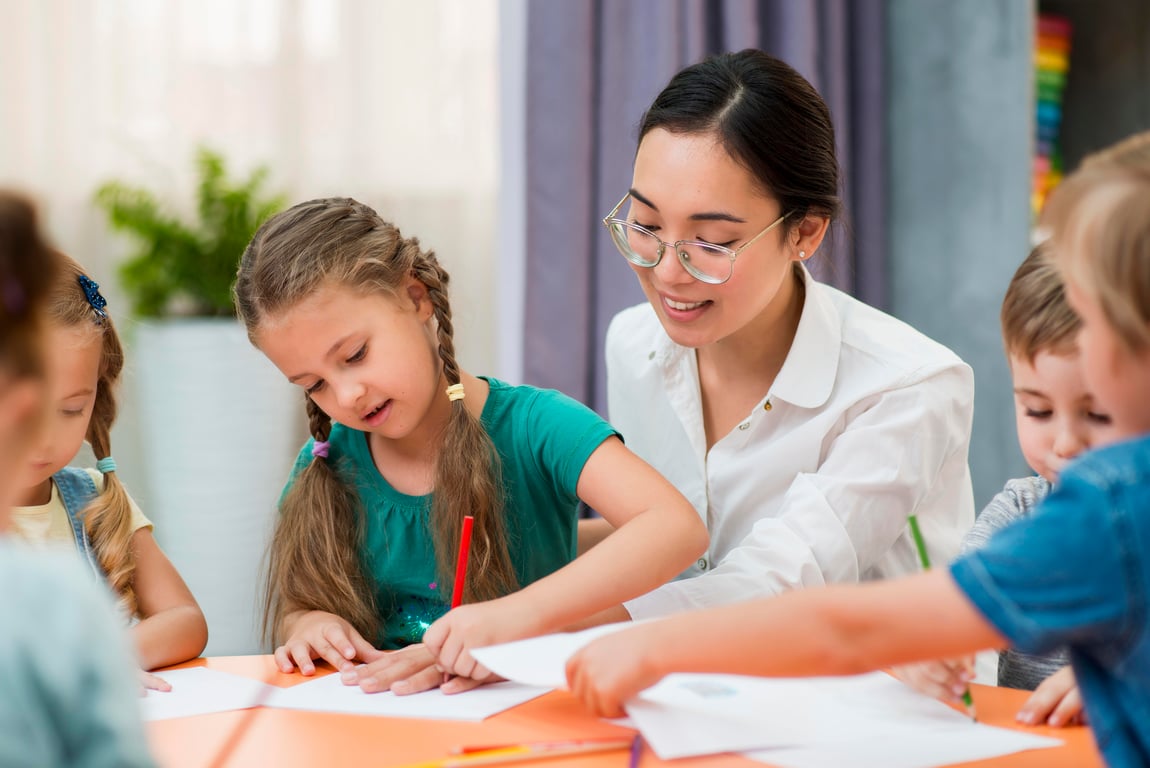 Professora em sala de aula com alunos do ensino fundamental, em ambiente iluminado e organizado