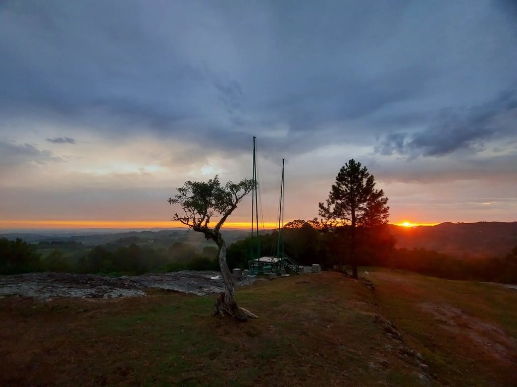 Estrada rural entre coxilhas ao pôr do sol, na região central do Rio Grande do Sul