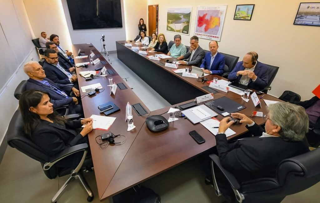 Ambiente administrativo com equipe reunida em mesa de trabalho