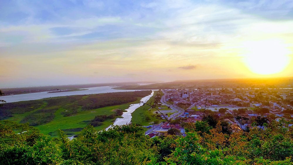 Vista aérea de Registro SP com o rio Ribeira de Iguape e a Mata Atlântica ao fundo, ao entardecer