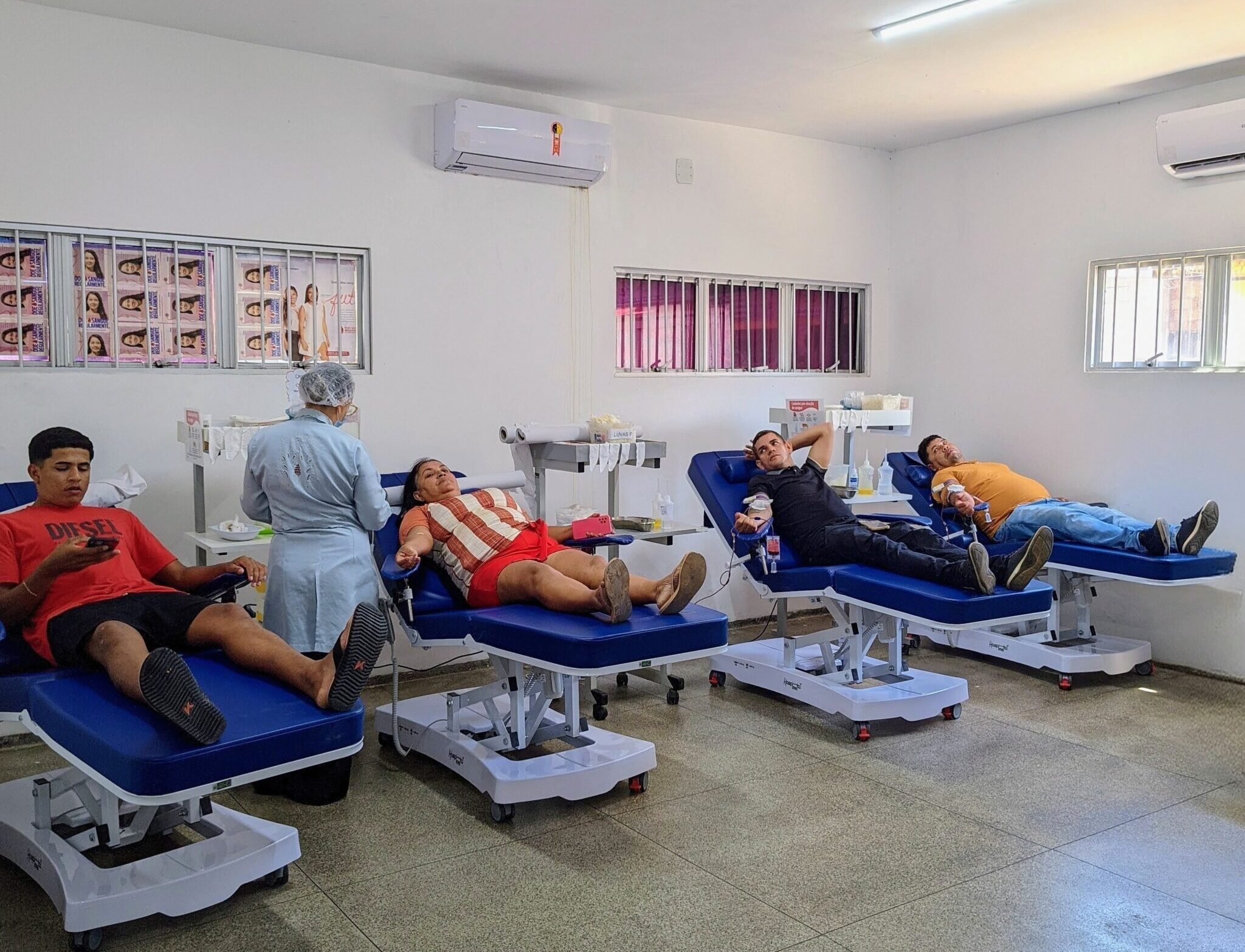 Interior de hemocentro com doação de sangue em andamento, ambiente moderno, horizontal