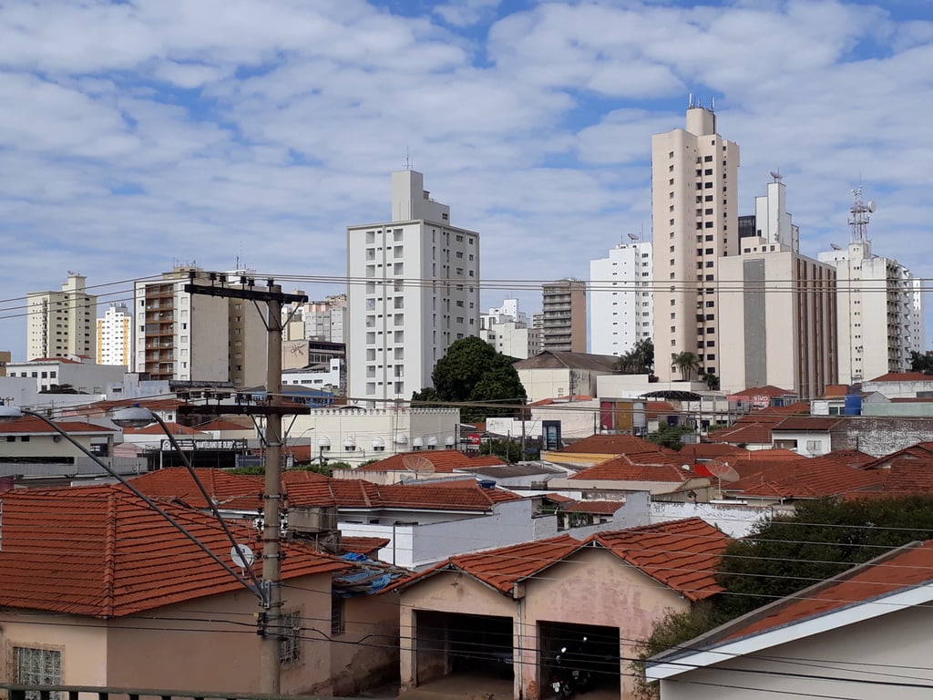 Vista aérea de cidade do interior de São Paulo, com telhados cerâmicos e áreas verdes ao redor