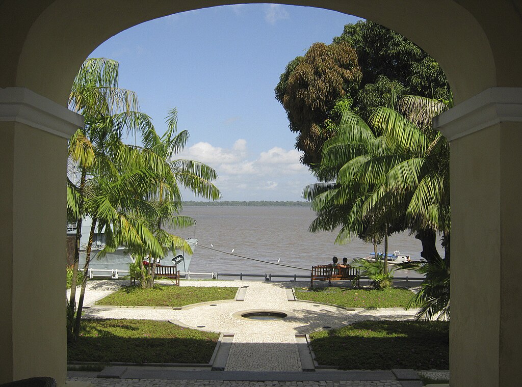 Vista panorâmica amazônica ao entardecer, com vegetação e espelho d’água ao fundo