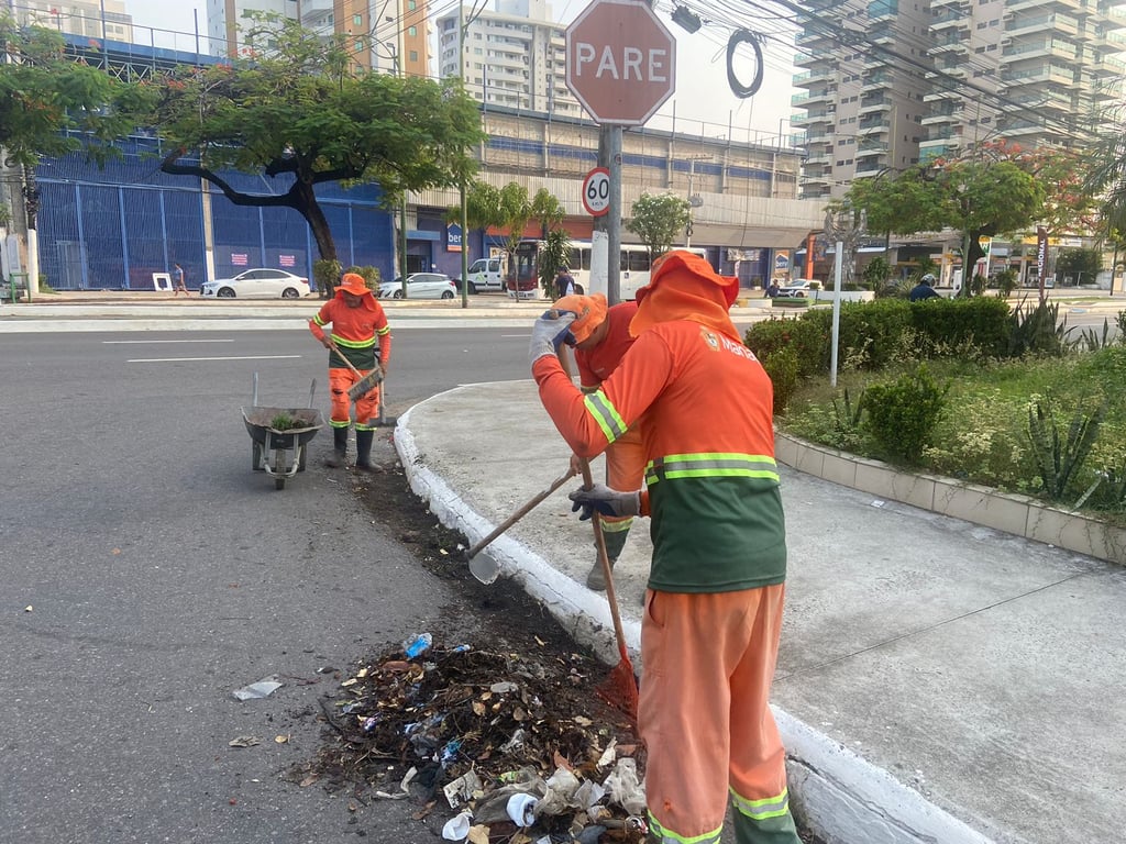 Trabalhadores de serviços urbanos realizando limpeza em via pública