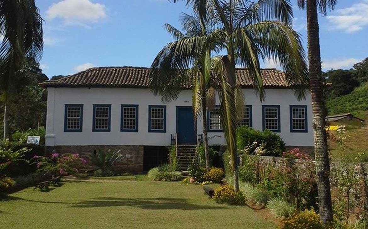 Fazenda histórica no Vale do Café, com vegetação de serra e luz natural