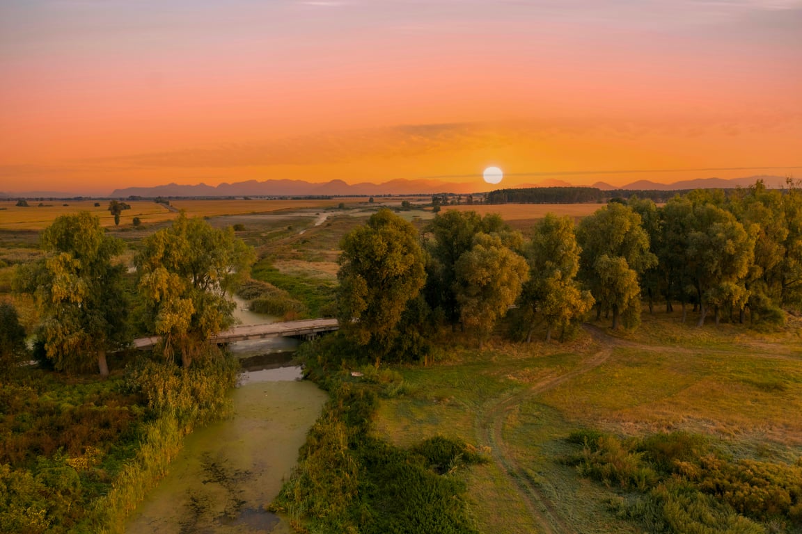 Paisagem rural no interior do Rio Grande do Sul com lavouras e colinas ao entardecer