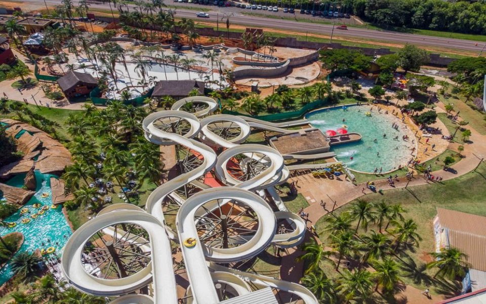 Parque aquático com toboáguas e grandes piscinas em Olímpia SP, céu azul e visitantes