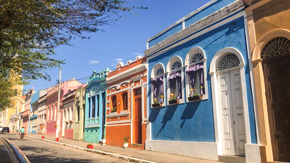 Rua histórica no Brejo Paraibano ao entardecer, com casario colorido e clima de interior