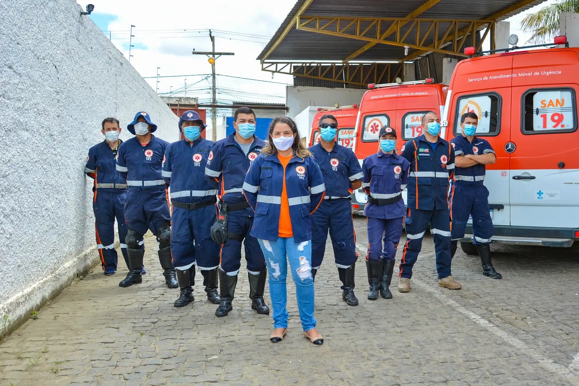 Equipe do SAMU em frente a ambulâncias