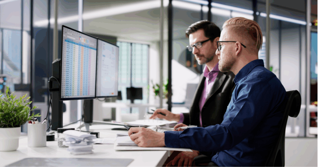 Profissionais analisando planilhas e notas no setor financeiro