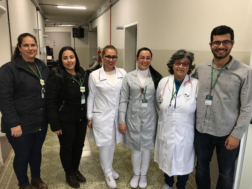 Equipe multiprofissional em corredor hospitalar universitário
