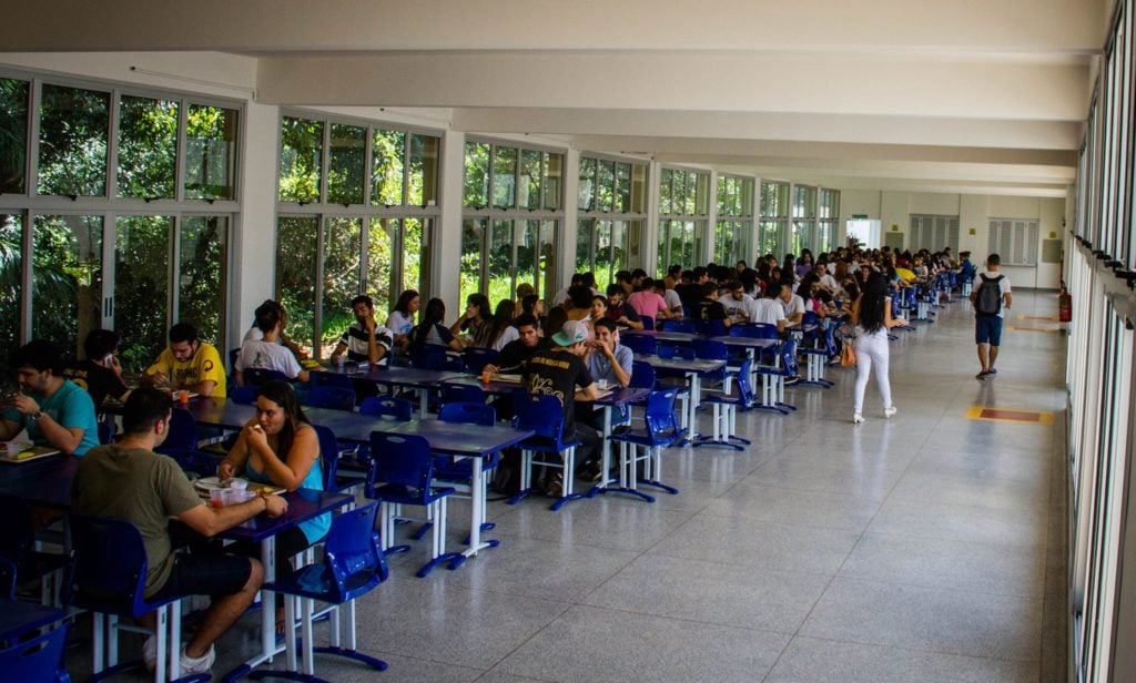 Ambiente universitário com estudantes, sugerindo campus federal e vida acadêmica