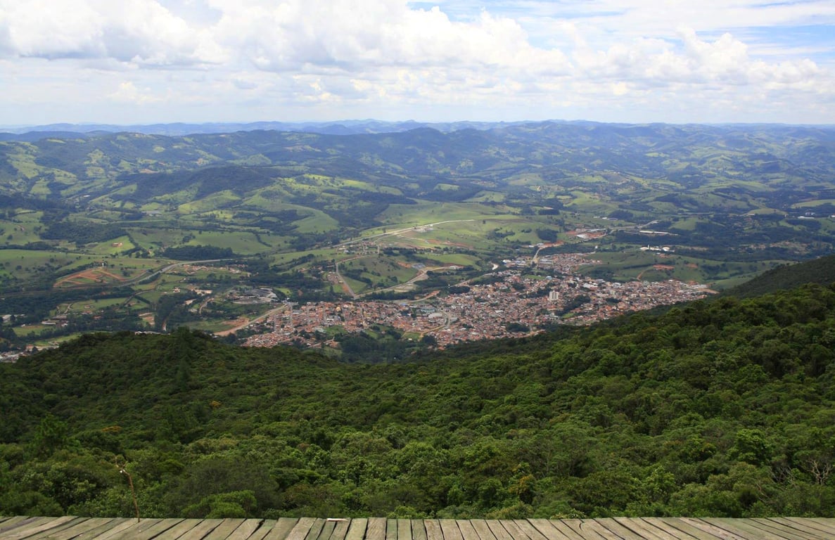 Rodovia em região montanhosa de Minas Gerais, com céu azul e serras ao fundo