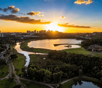 Vista urbana de Limeira ao entardecer, com lagoa e prédios ao fundo