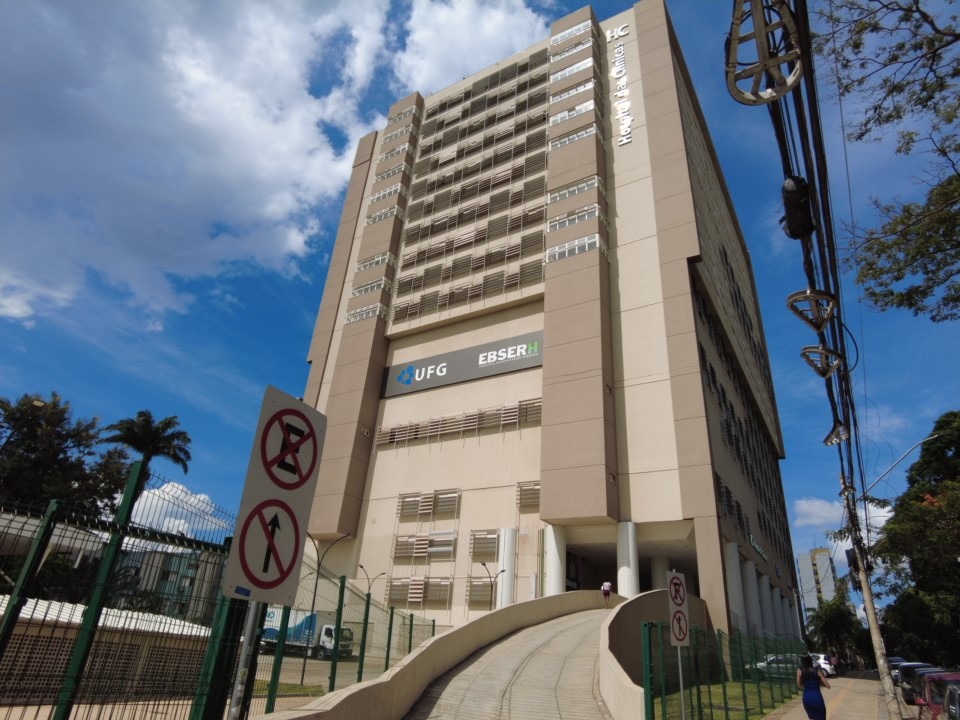 Fachada do HC-UFG com movimentação na entrada e céu aberto