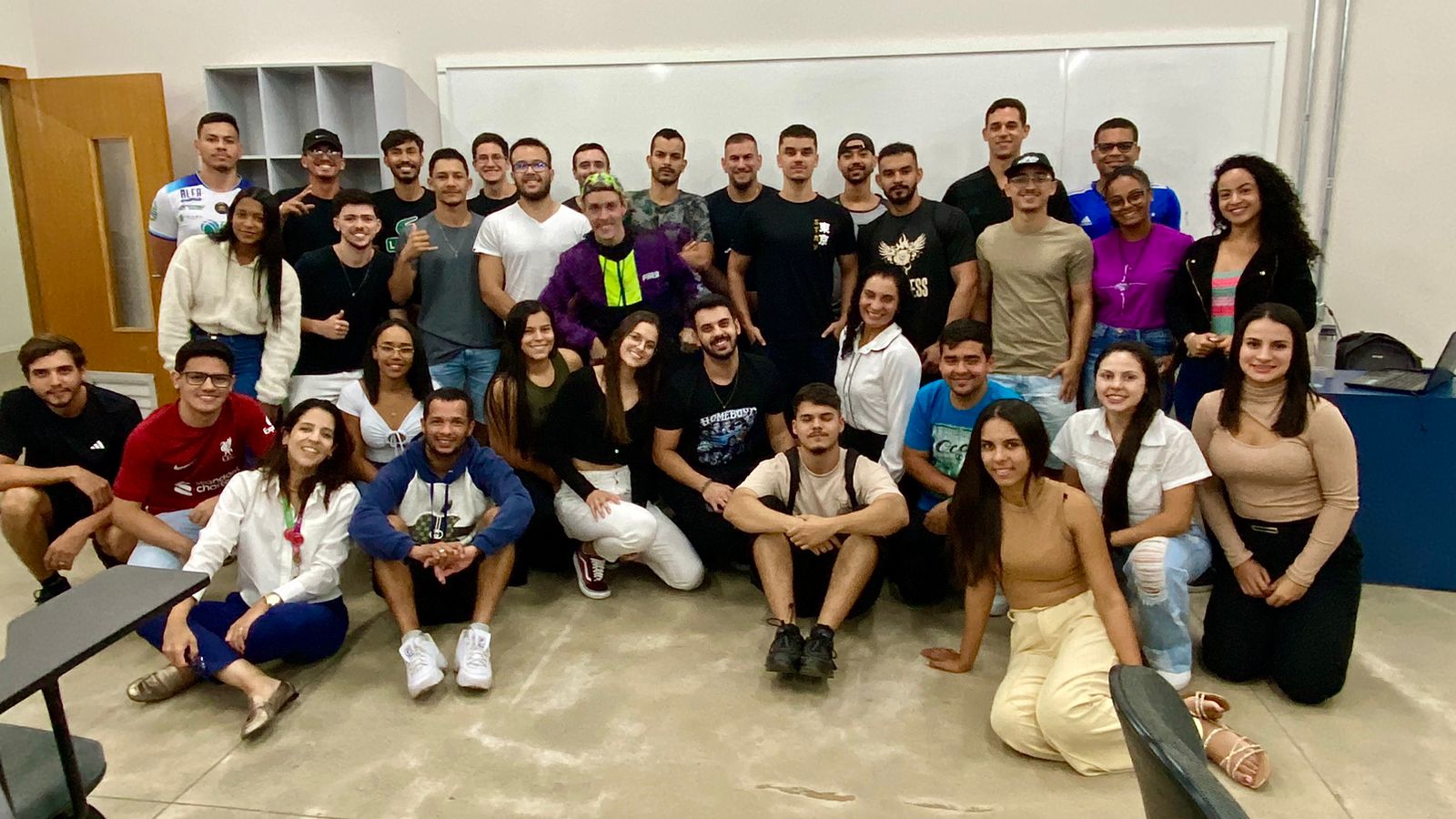 Ambiente interno com grupo de alunos e instrutor, simbolizando prática esportiva educacional