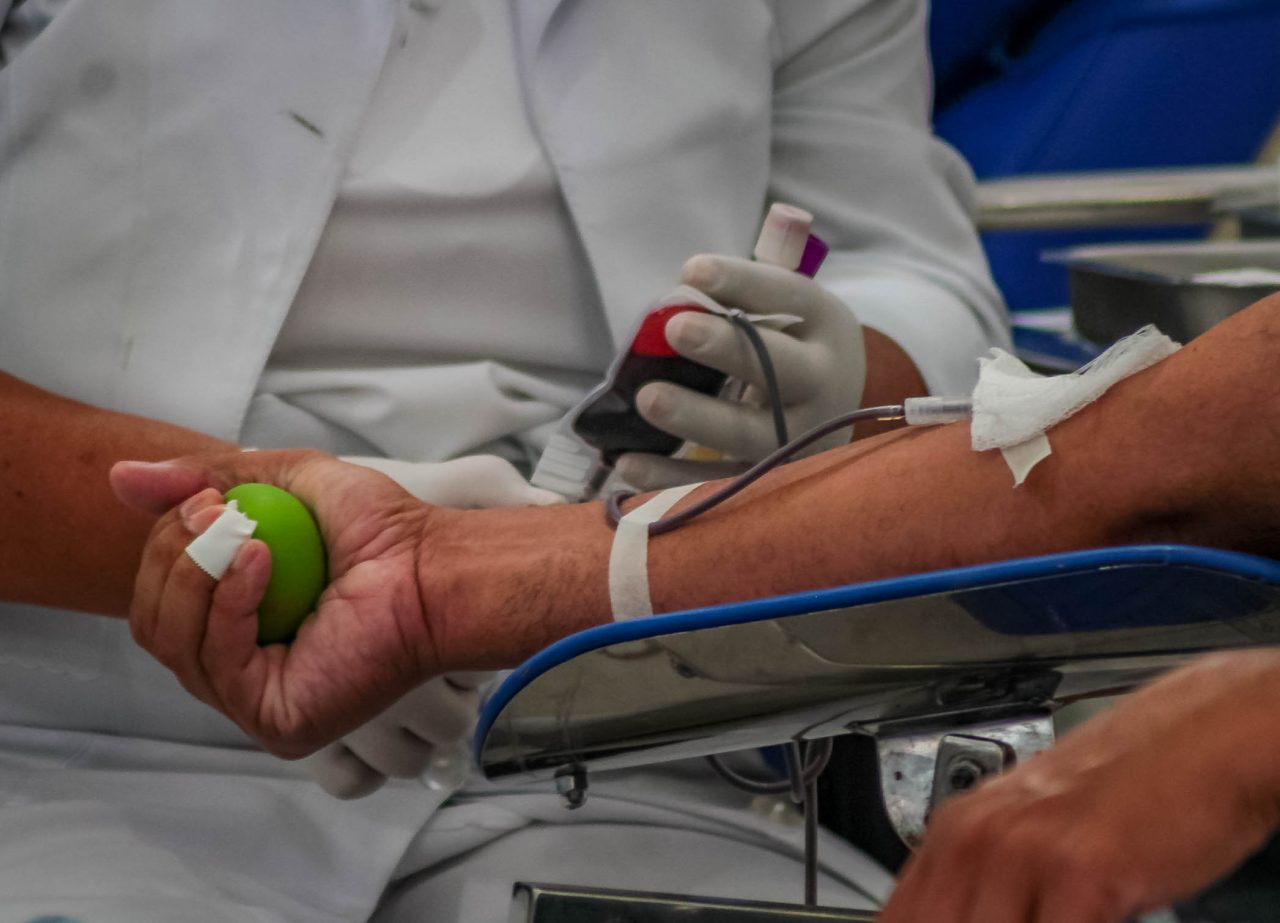 Profissionais em ambiente de hemoterapia manipulando hemocomponentes