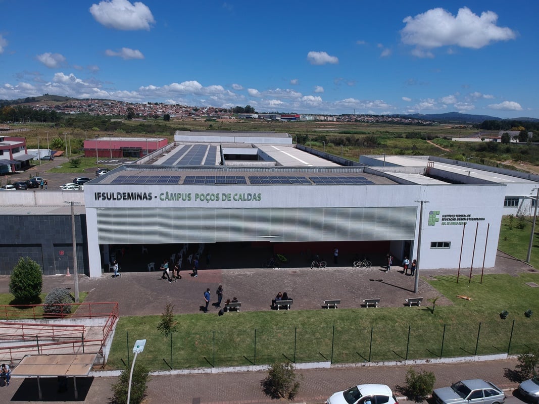 Imagem institucional do campus do IFSULDEMINAS, em perspectiva aérea, com estudantes circulando na entrada