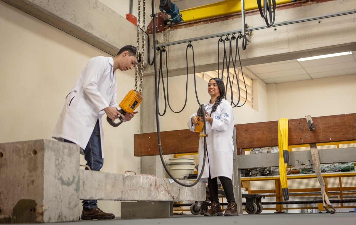 Atividades práticas em laboratório de engenharia, com equipe em jalecos operando equipamentos