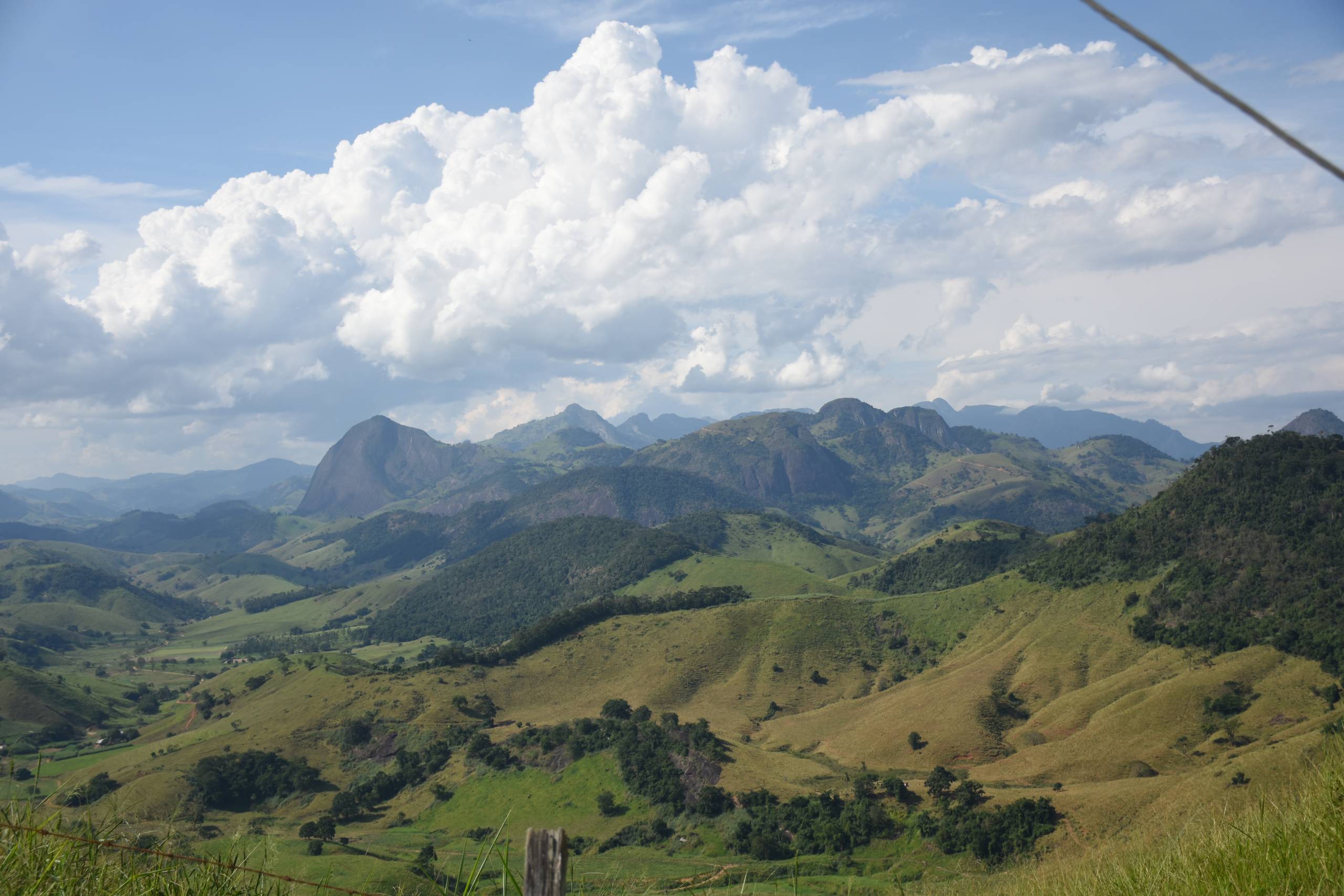 Vista aérea de Alegre ES, com morros ao fundo e céu parcialmente nublado