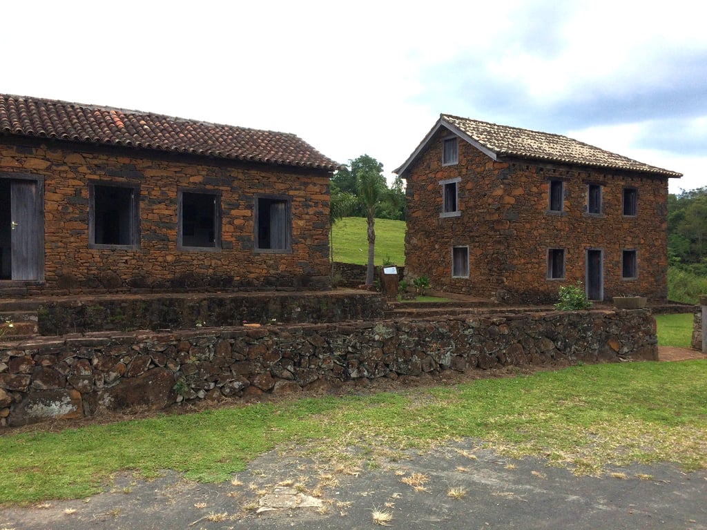 Foto de casas em estilo de imigração europeia em uma pequena cidade catarinense. A cena mostra detalhes arquitetônicos de edifícios em meio a um ambiente rural.