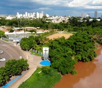 Avenida principal de Marcelândia MT em dia ensolarado, com prédios baixos e palmeiras.