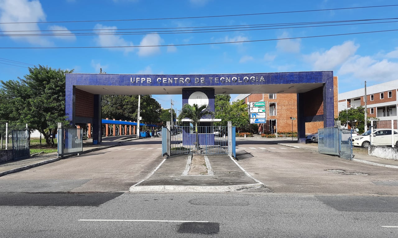 Entrada do campus da UFPB em João Pessoa, com jardins e edifícios acadêmicos ao fundo