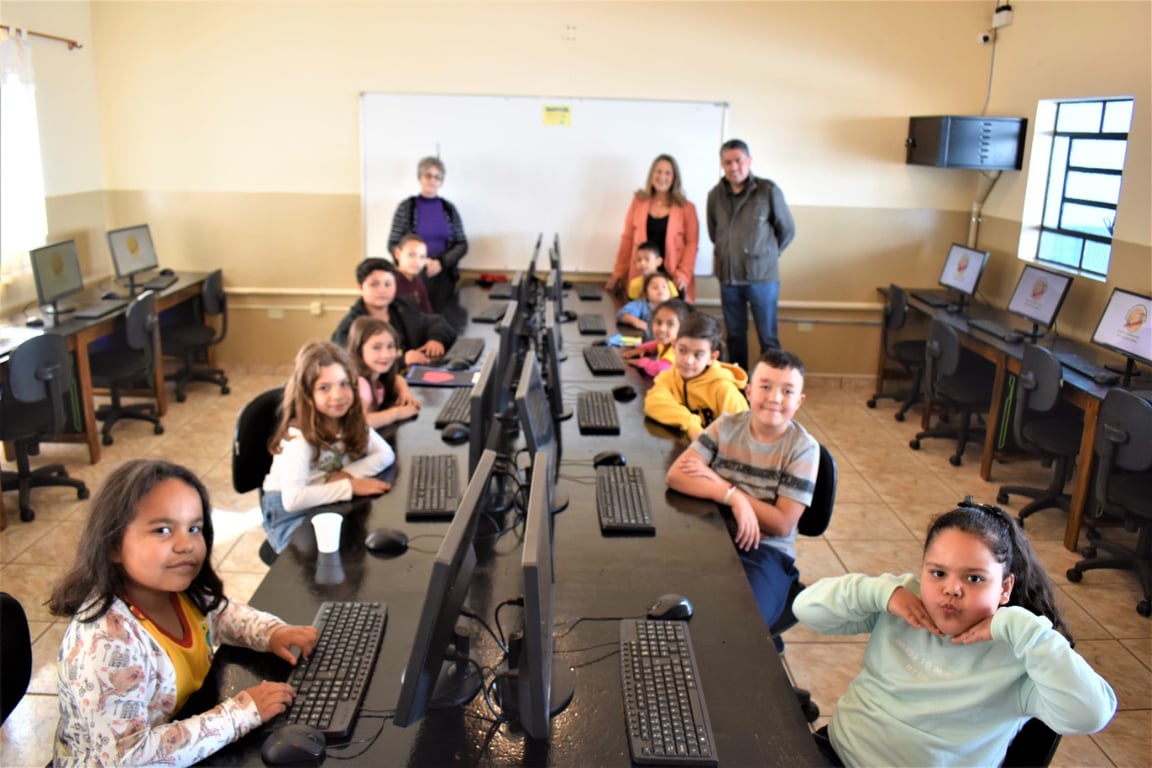 Laboratório de informática com professor e estudantes em atividade de programação