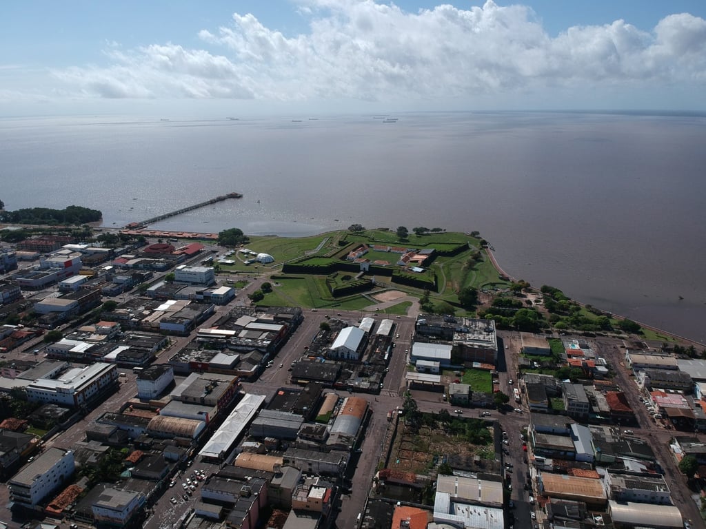 Vista aérea de Macapá às margens do Rio Amazonas, com a Fortaleza de São José ao fundo, ao entardecer