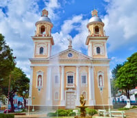 Vista aérea do centro histórico de Amparo SP em dia ensolarado, mostrando igreja matriz e casario.