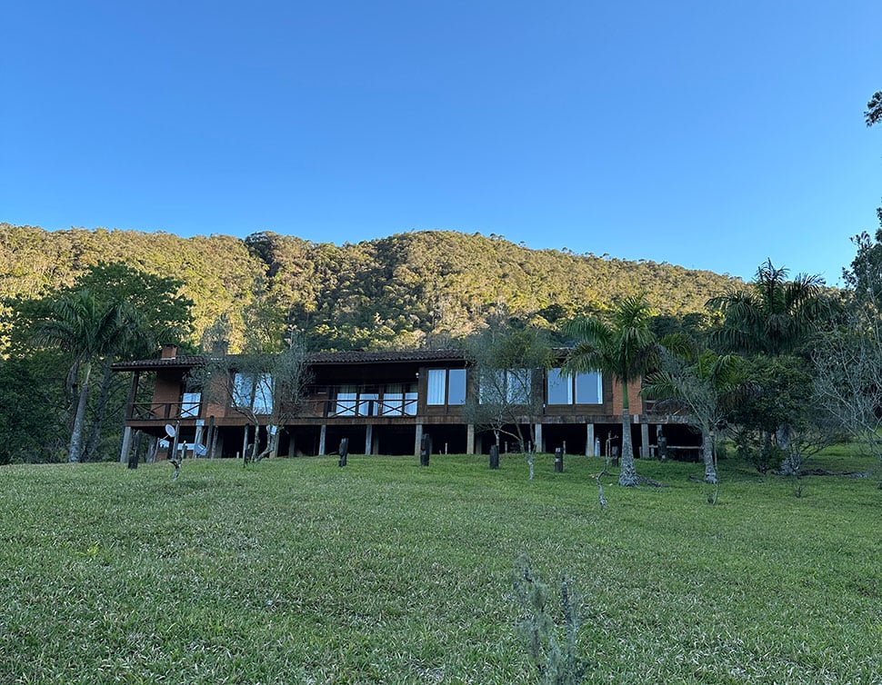 Paisagem rural na Serra da Mantiqueira, com morros verdes ao pôr do sol