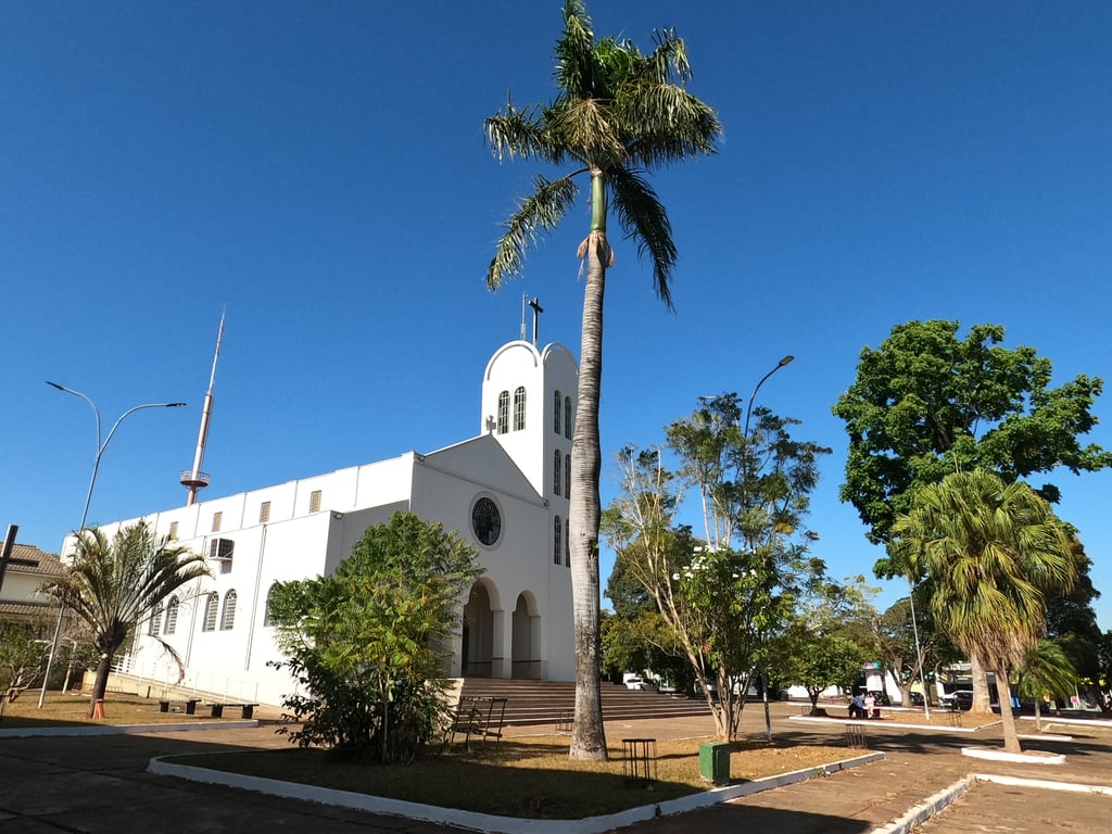 Vista urbana de Iporã, com igreja, palmeiras e céu limpo ao fundo