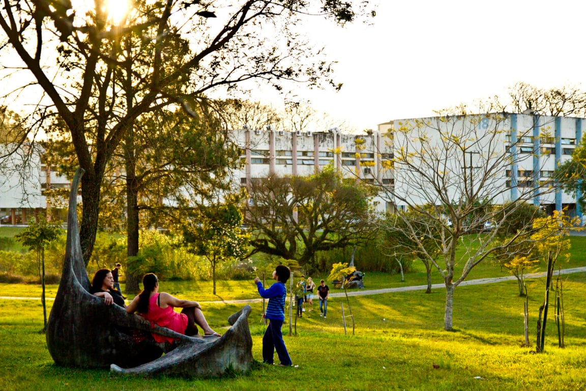Campus da UFSM com estudantes em área de convivência, sob céu claro