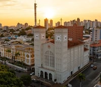 Skyline de Cuiabá ao pôr do sol, com prédios iluminados e atmosfera quente do Centro-Oeste.